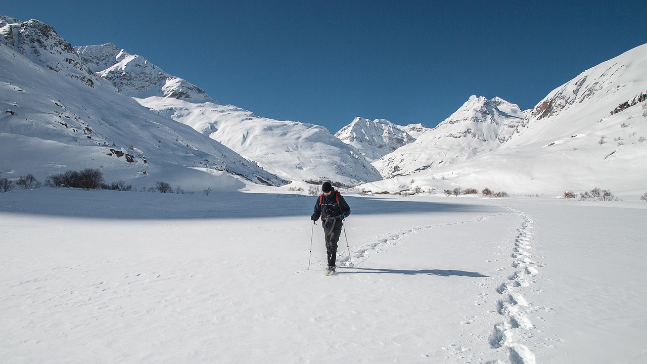 best trekking poles - a hiker holding lightweight carbon fiber trekking poles on a steep alpine mountain trail