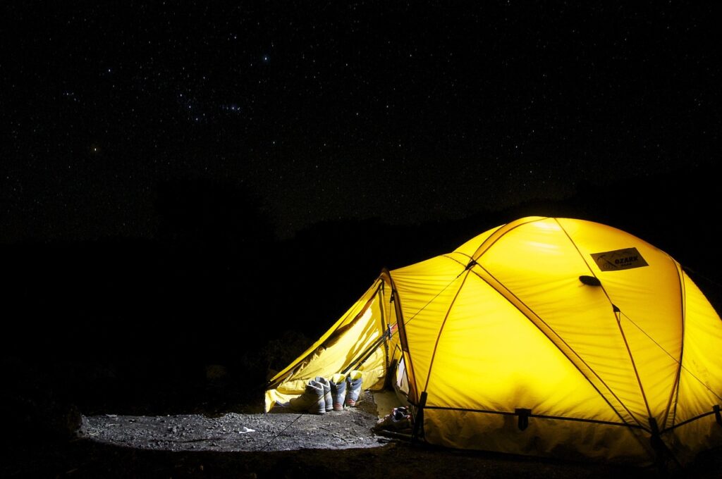Soft warm string lights illuminated inside a spacious camping tent at night