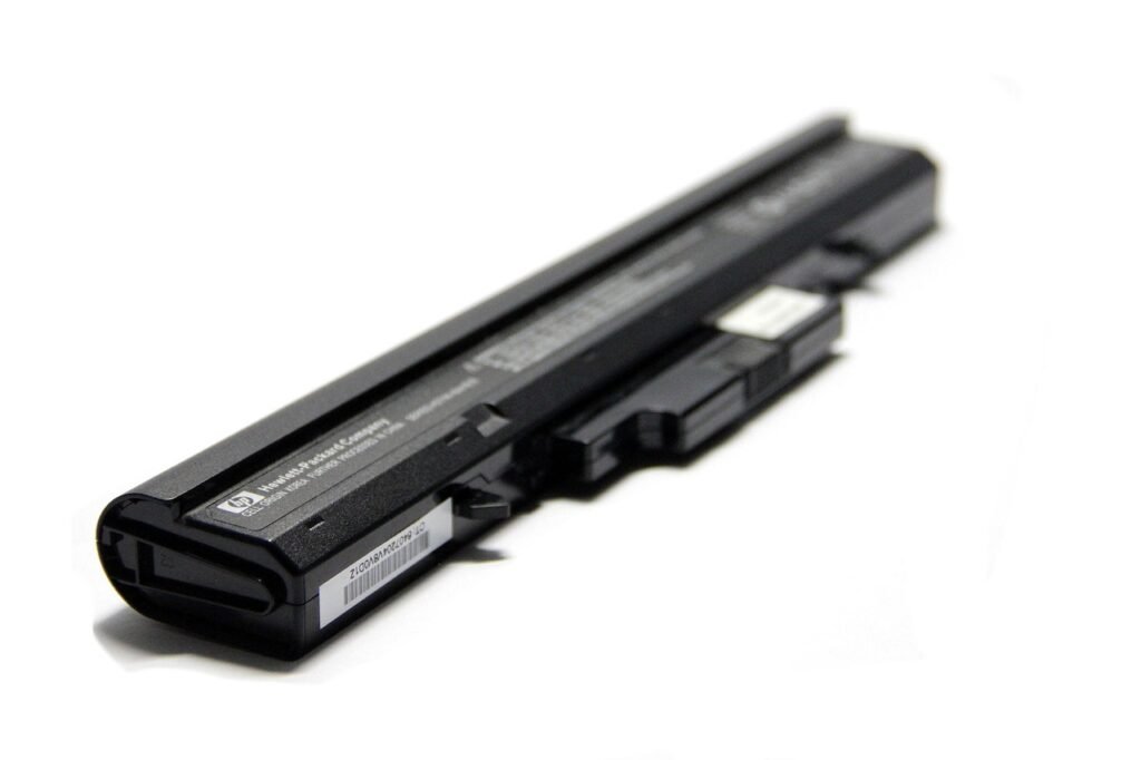 action camera with mounting hardware and spare batteries laid out on a wooden tabletop