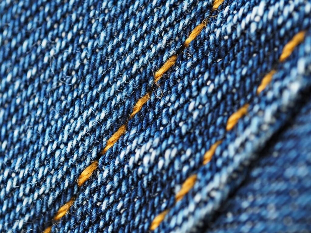 close up texture of technical woven synthetic hiking pants fabric showing water droplets beading on the surface