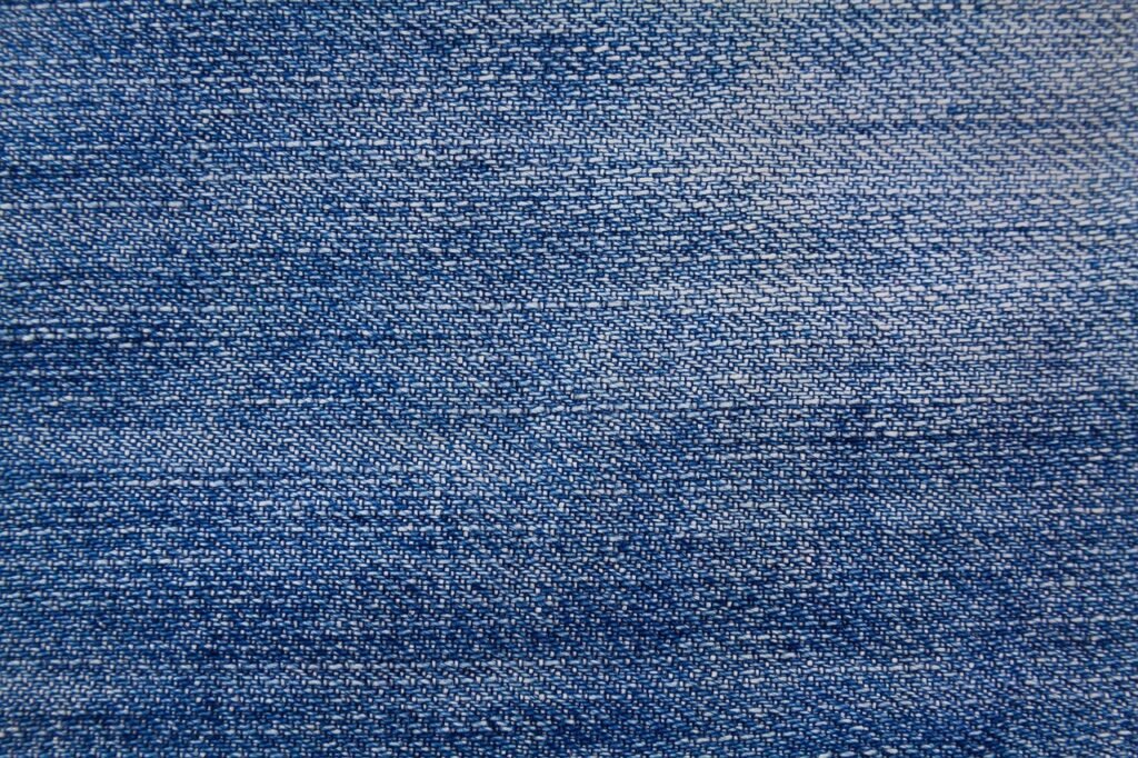 close up texture of technical woven synthetic hiking pants fabric showing water droplets beading on the surface